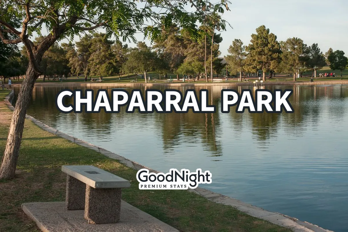 A serene park scene featuring calm water, park benches, people enjoying the green space, and a line of trees in the background. The ambiance invites relaxation and casual social gatherings in nature.